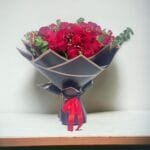 Red Rose Ensemble: Mixed Red Roses and Spray Roses with Eucalyptus in Black and Red