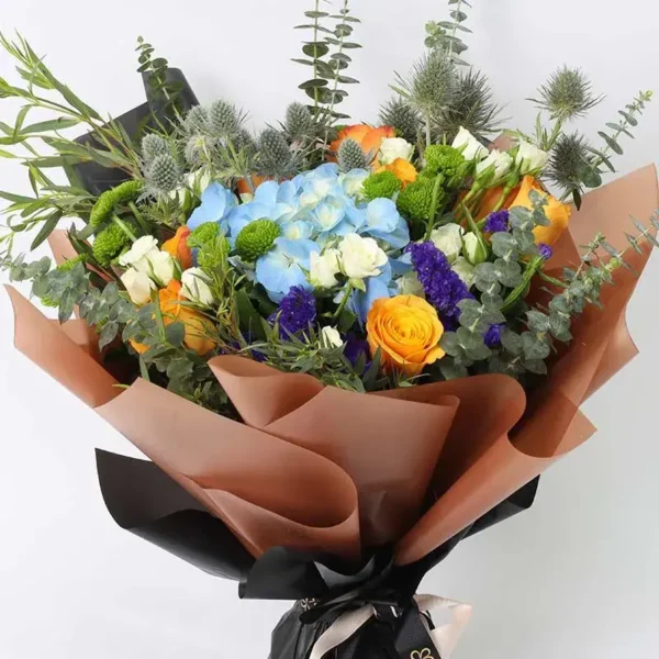 Floral Forest Bouquet: Blue Hydrangea, Orange Roses, White Baby Roses, Eryngium, Green Button Chrysanthemum, Blue Statice | Brown and Black Wrap