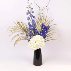 Heavenly Blooms: Flowers Artfully Arranged in Black Vase ? White Hydrangea, Blue Delphinium, Golden Sprayed Areca Palm Leaves