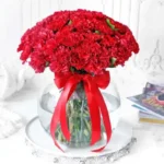 Red Carnation Delight: Blooms in a Fish Bowl - 50 Red Carnations, Green Leaves, Glass Vase