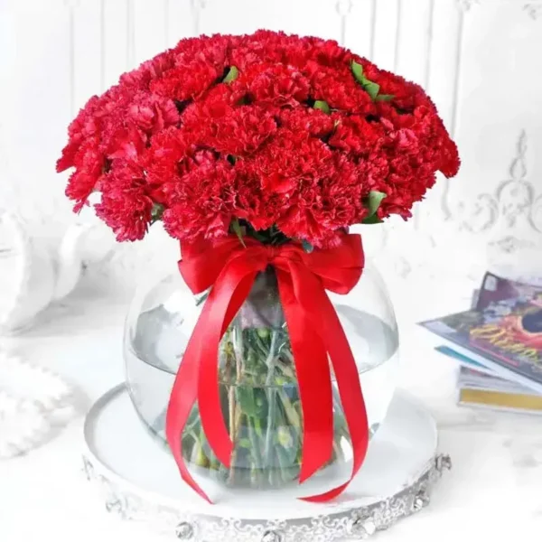 Red Carnation Delight: Blooms in a Fish Bowl - 50 Red Carnations, Green Leaves, Glass Vase
